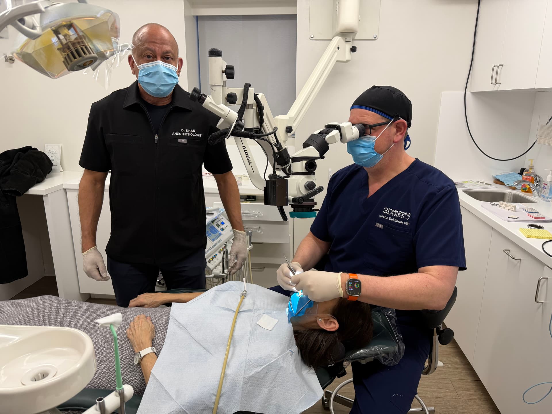 Dr. Khan supporting an endodontist during microscope-assisted treatment