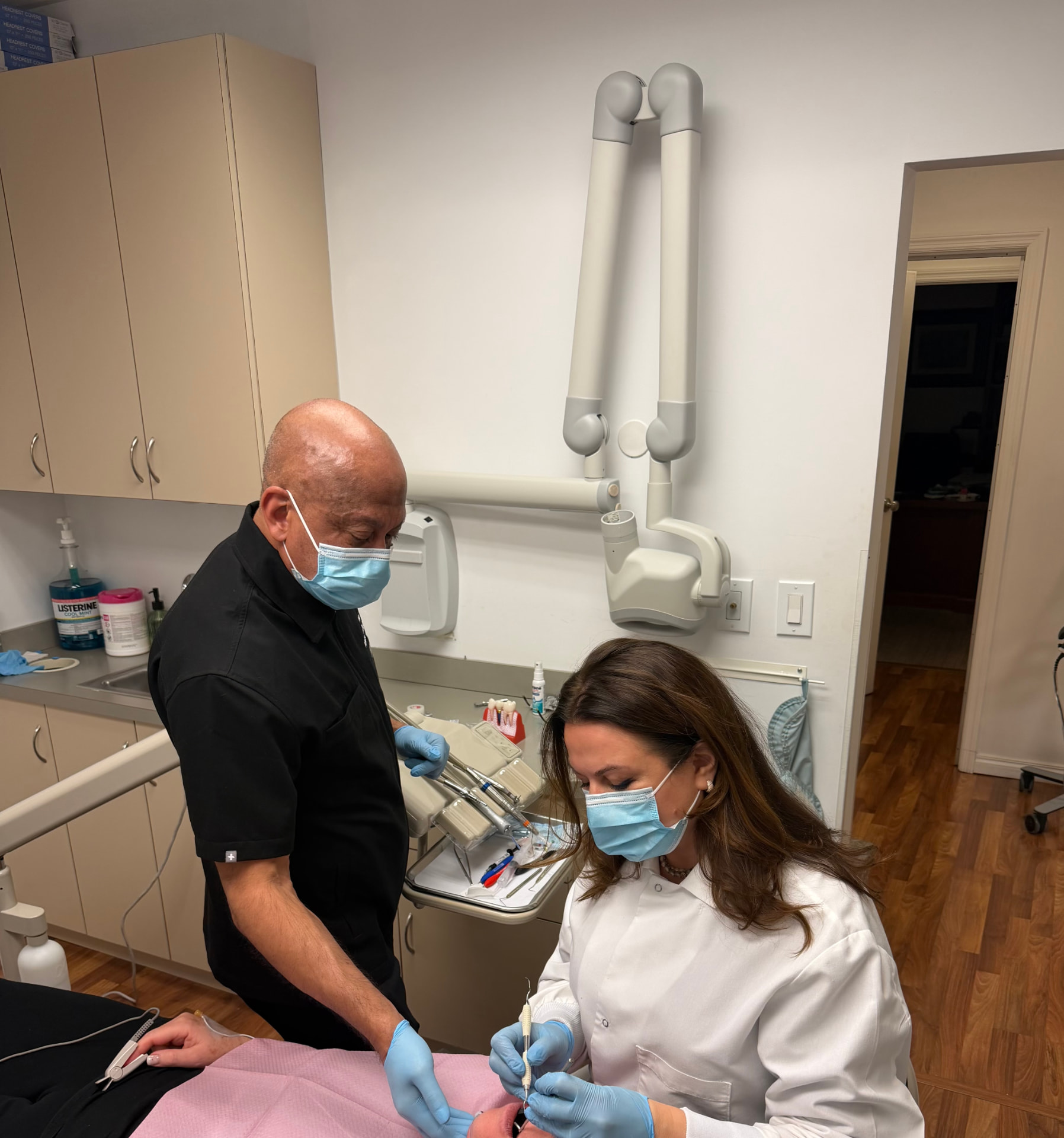 Dr. Khan providing anesthesia support alongside a restorative dentist